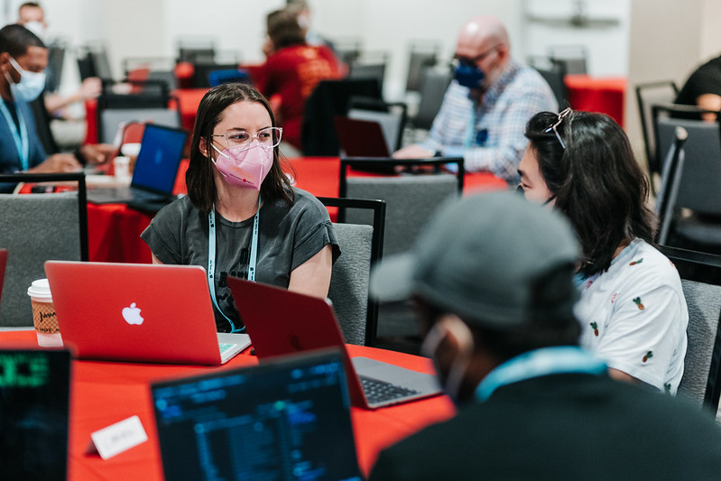 Two Development Sprints attendees at DjangoCon US 2022 in San Diego, chatting.